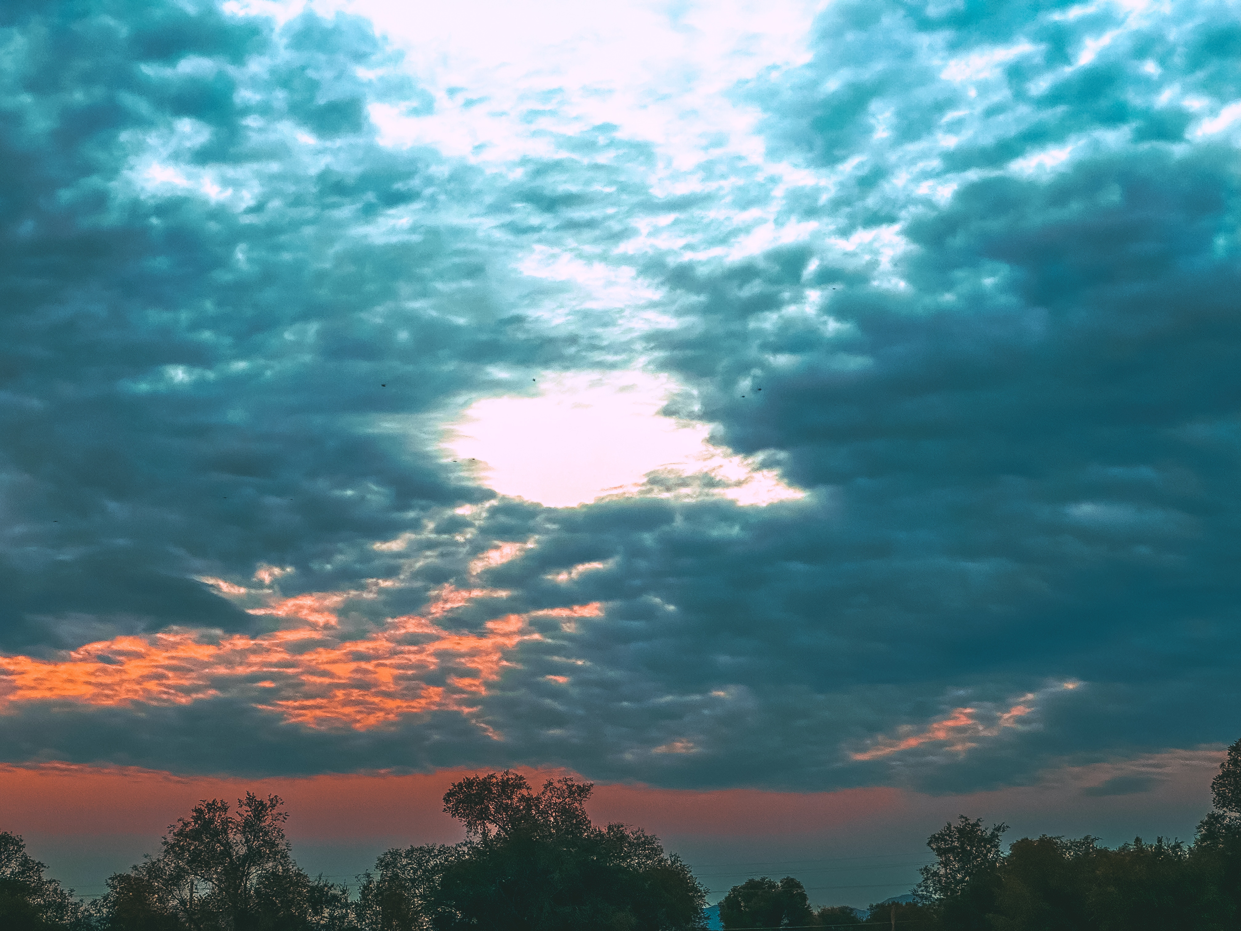 An ethereal scene as the sunrise gleams through dark clouds.