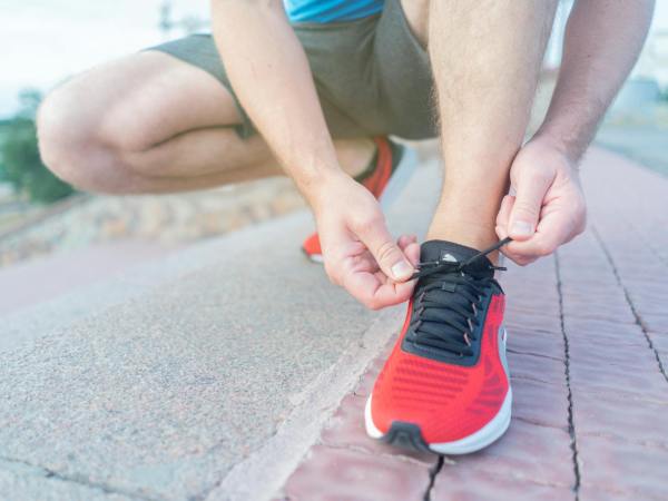 close up shot of person tying his red sneakers