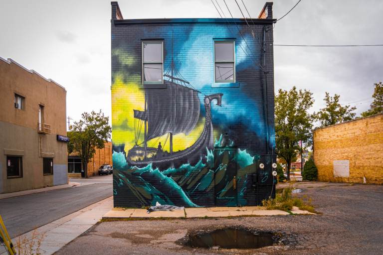 Imagine a mural of a ship painted on the back of a building along historic Main Street in Midvale, Utah during downtown renovation