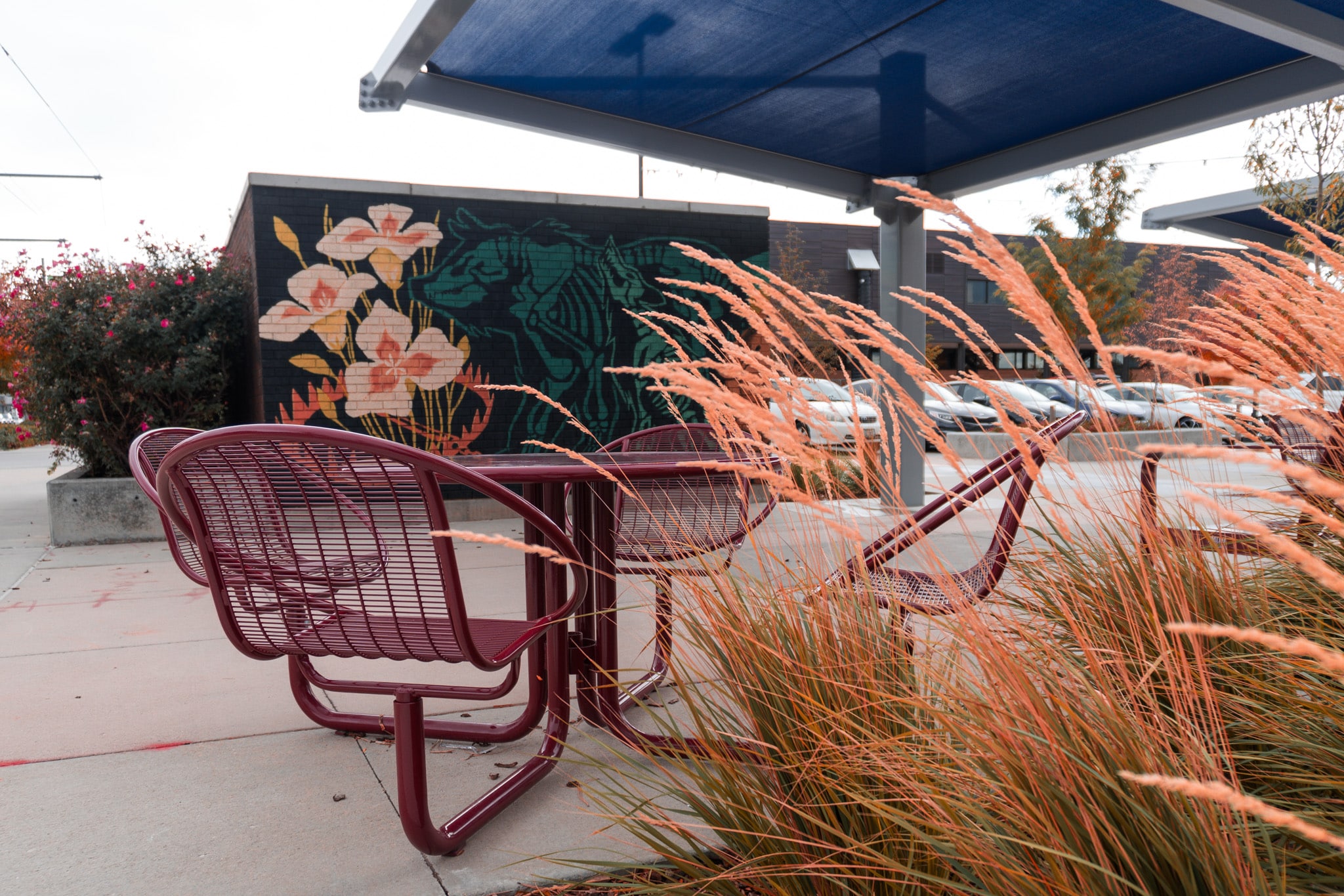 Outdoor patio chairs beside ornamental grass and mural used as feature image for poetry revision workshop post