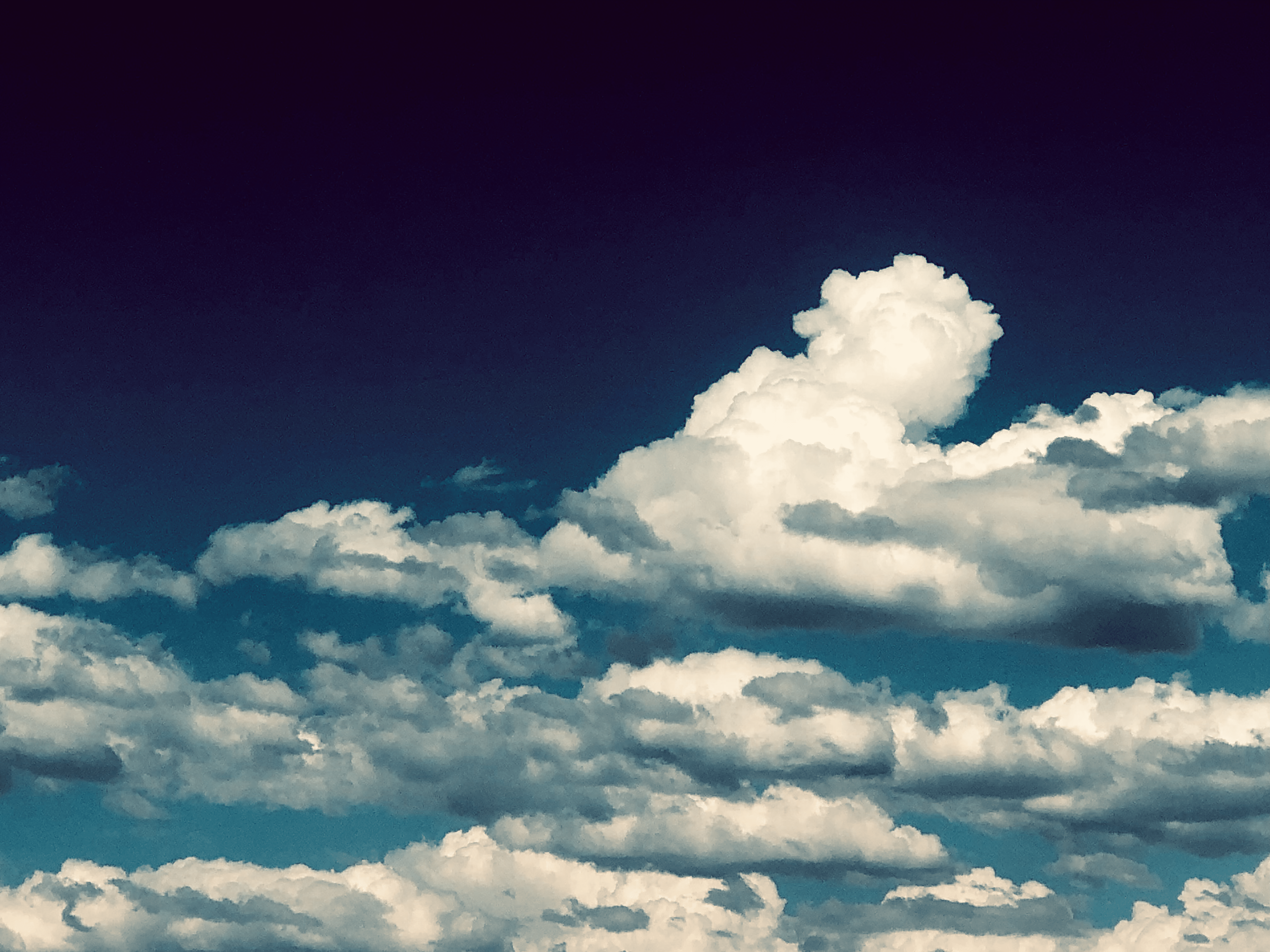 Clouds congregate under wanting skies.