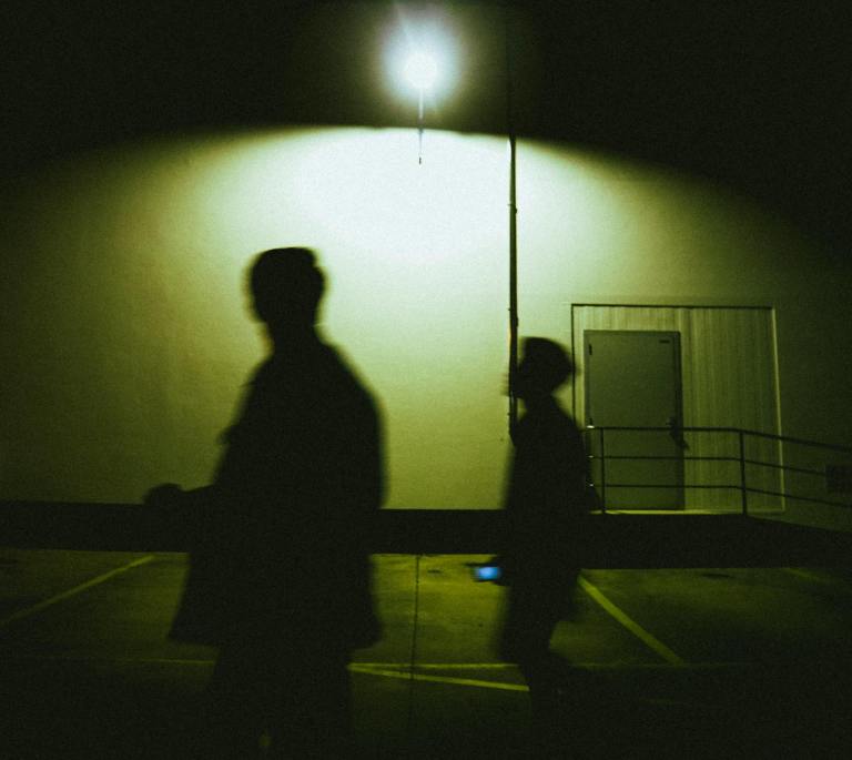 silhouettes of people on street at night