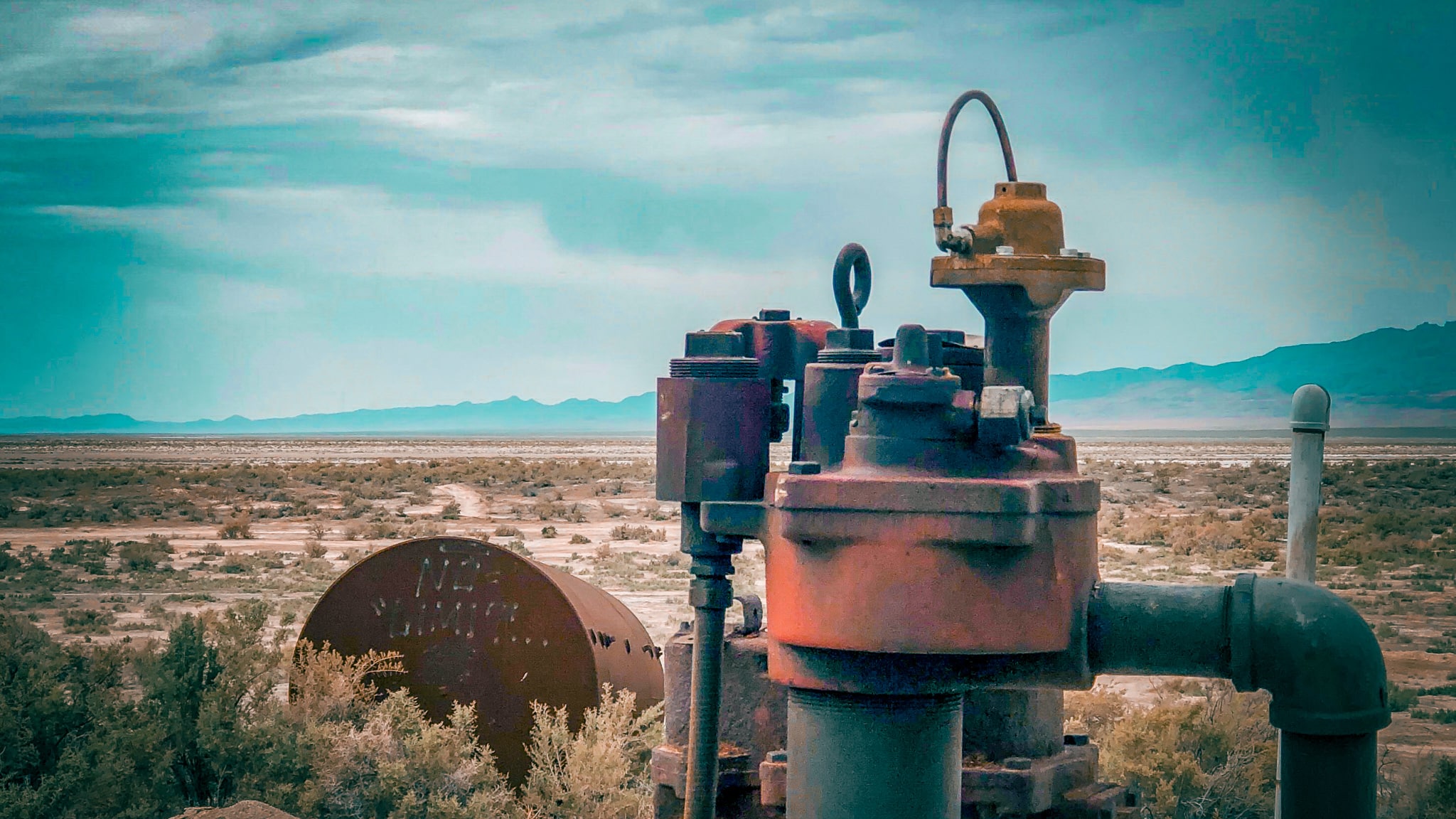 Industrial water pump in dry landscape representing a civics metaphor about resource use